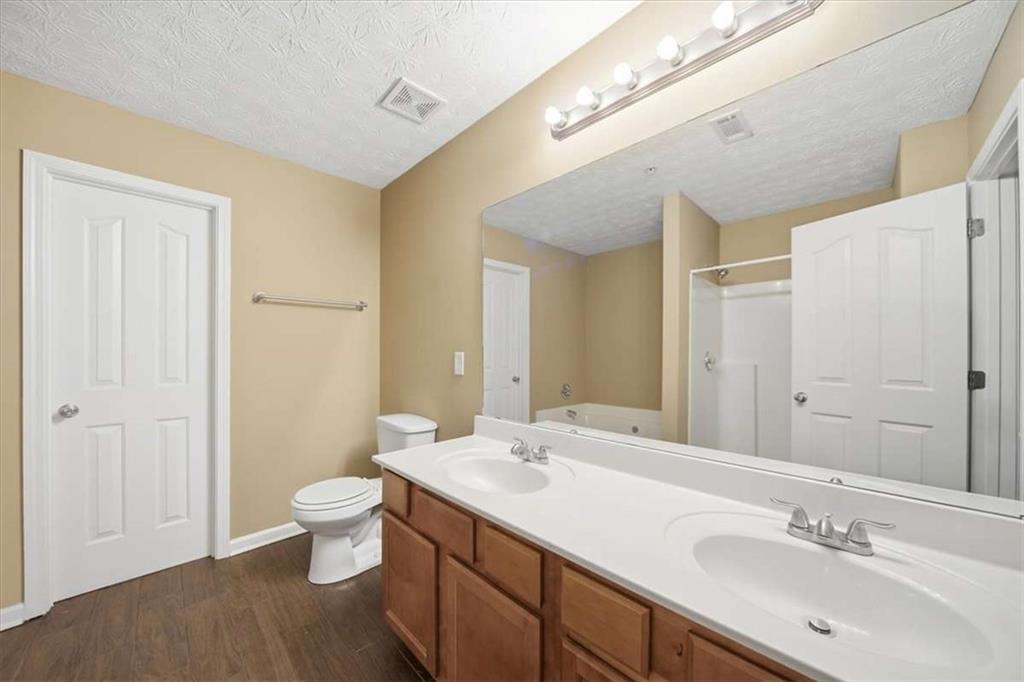 3834 Augustine Place Rex, GA 30273 - Photo 25 of 41 a bathroom with a double vanity sink a toilet and a mirror