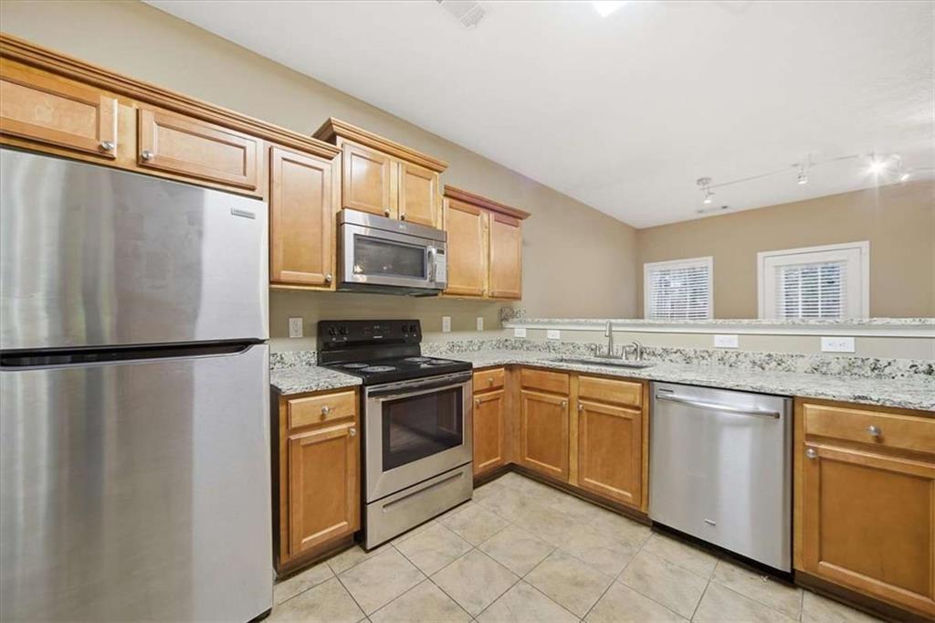 3834 Augustine Place Rex, GA 30273 - Photo 8 of 41 a kitchen with stainless steel appliances granite countertop a refrigerator a stove a sink and a microwave
