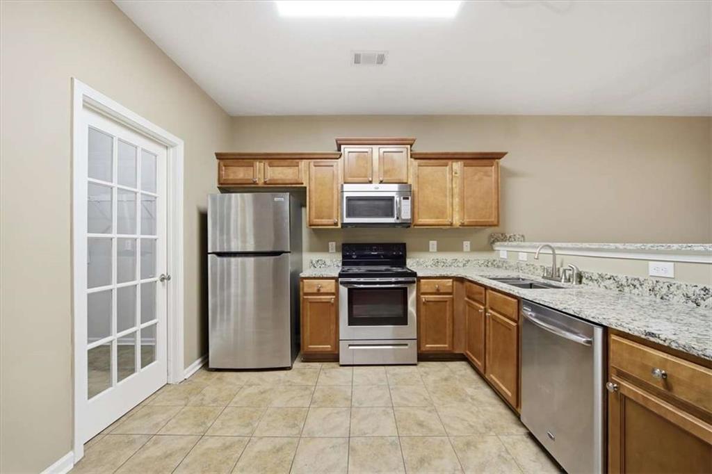 3834 Augustine Place Rex, GA 30273 - Photo 9 of 41 a kitchen with stainless steel appliances granite countertop a stove top oven a sink and a refrigerator