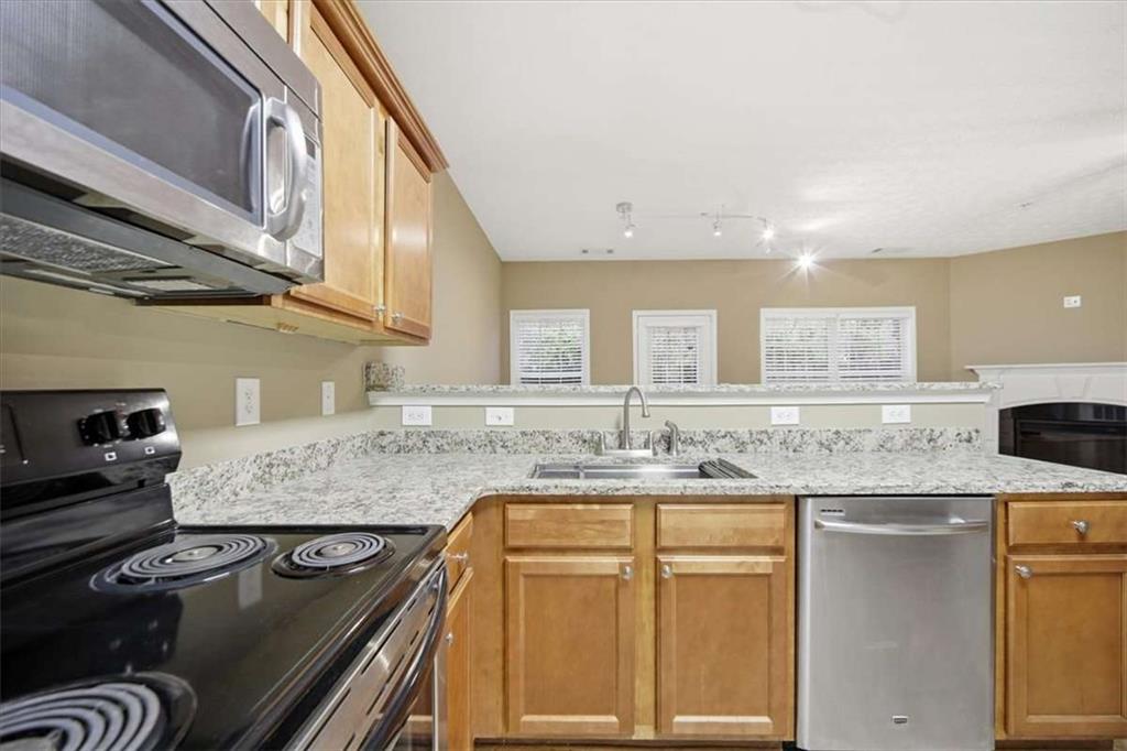 3834 Augustine Place Rex, GA 30273 - Photo 10 of 41 a kitchen with kitchen island granite countertop a sink stove and cabinets