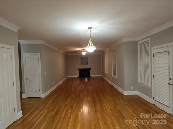 a view of a room with wooden floor a fireplace and window