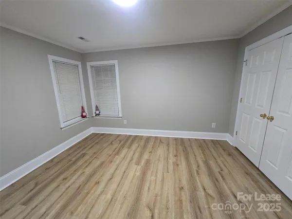 a view of an empty room with wooden floor