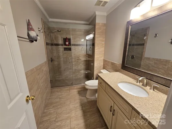 a bathroom with a granite countertop sink toilet and shower