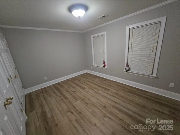 an empty room with wooden floor and closet