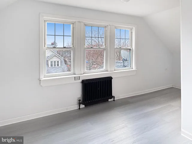 an empty room with a window and a dresser