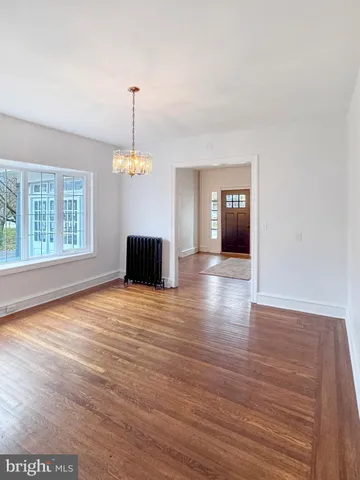 a view of a room with wooden floor fireplace and windows