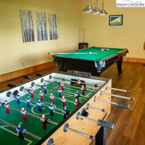 a room with pool table and paintings on the wall