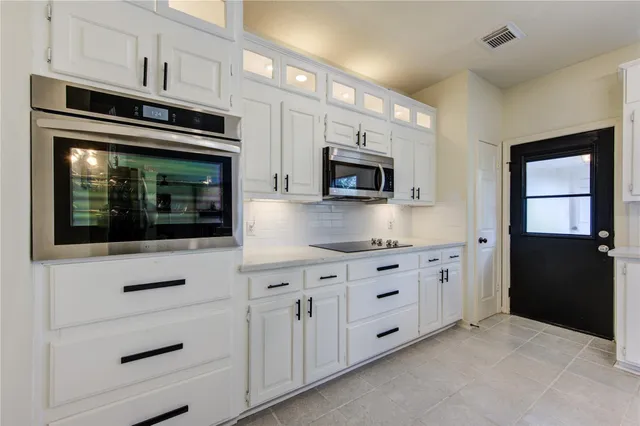 a kitchen with granite countertop white cabinets stainless steel appliances and sink
