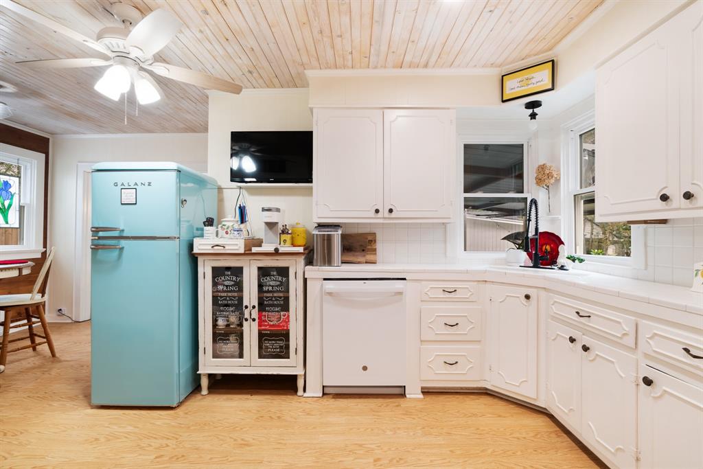 2257 Cleveland Street Paris, TX 75460 - Photo 11 of 39 Kitchen featuring tile counters, wood ceiling, freestanding refrigerator, white dishwasher, and white cabinetry