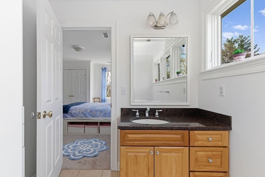228 Mossman Road Sudbury, MA 01776 - Photo 32 of 42 a bathroom with a granite countertop sink a mirror and cabinets