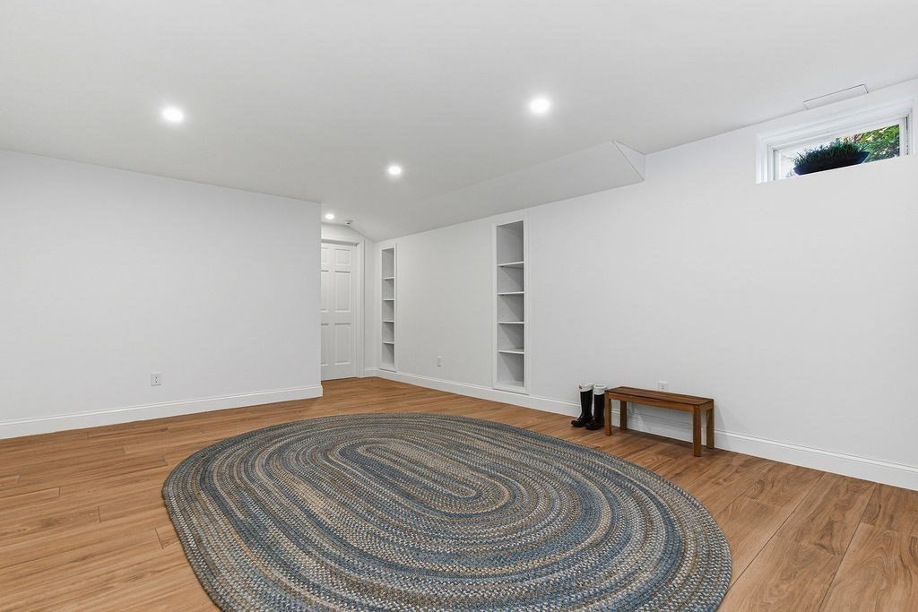 228 Mossman Road Sudbury, MA 01776 - Photo 39 of 42 a bedroom with a bed and a lamp with wooden floor