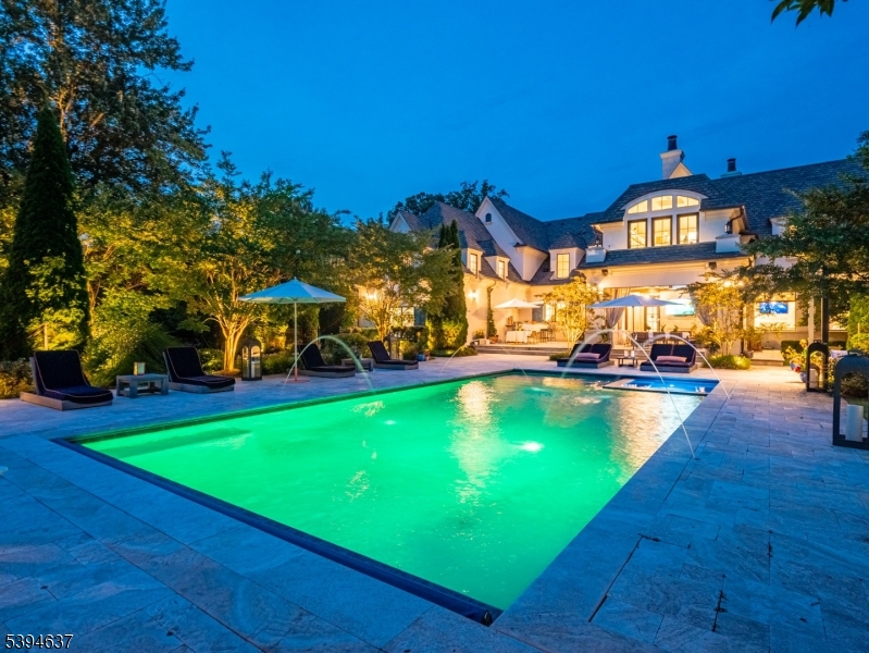 7 Stokes Farm Road Old Tappan, NJ 07675 - Photo 41 of 43 a view of a swimming pool with lawn chairs under an umbrella