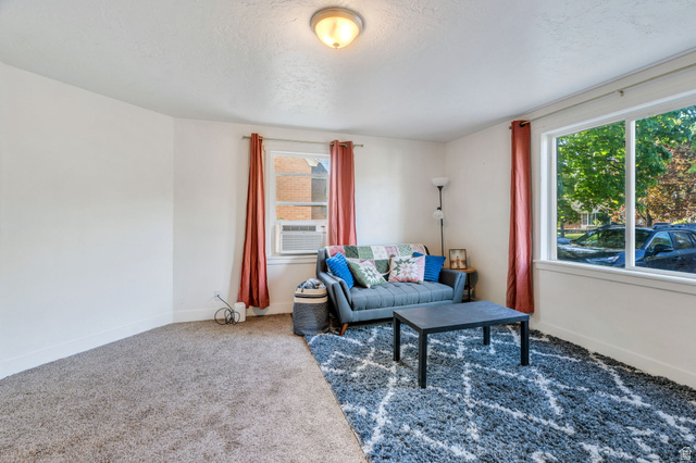 358 400 South Provo, UT 84601 - Photo 5 of 34 Carpeted living room with healthy amount of natural light and cooling unit.
