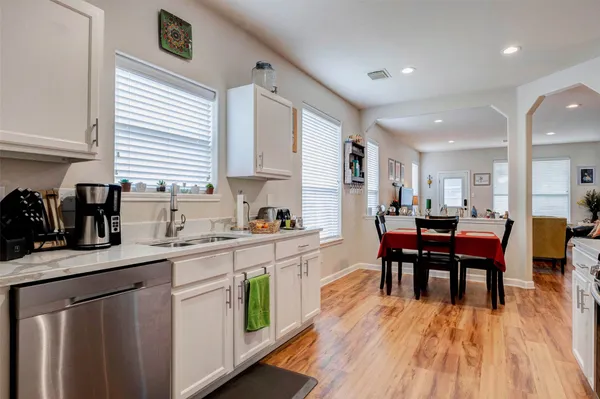 a kitchen with a sink a microwave cabinets and dining table
