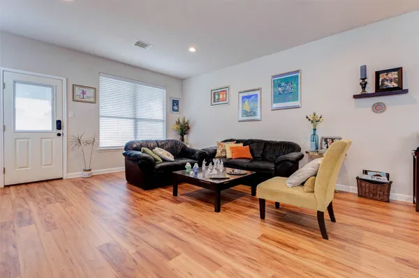 a living room with furniture and a wooden floor
