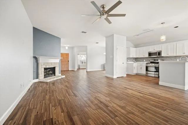 a view of a kitchen with wooden floor and a fireplace