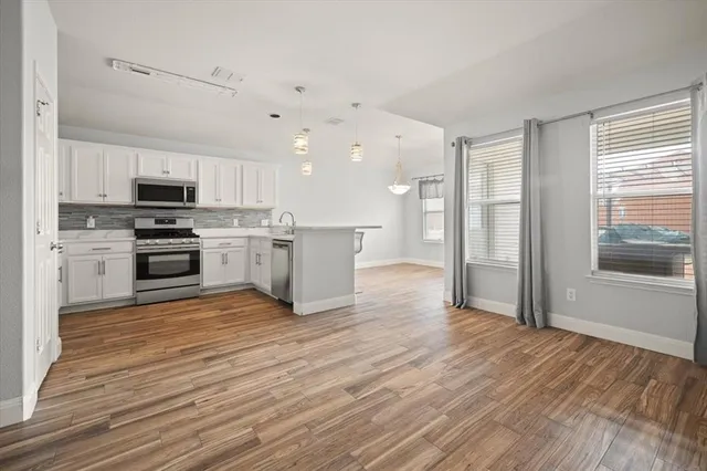 a view of kitchen with microwave a stove top oven and cabinets