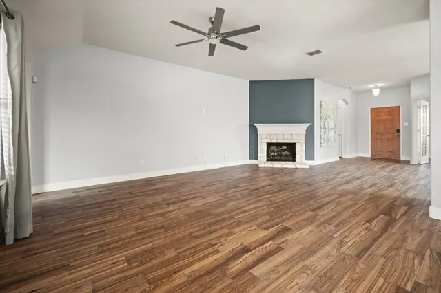wooden floor fireplace and windows in an empty room
