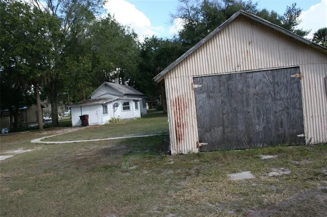 a view of a house with a yard and large tree