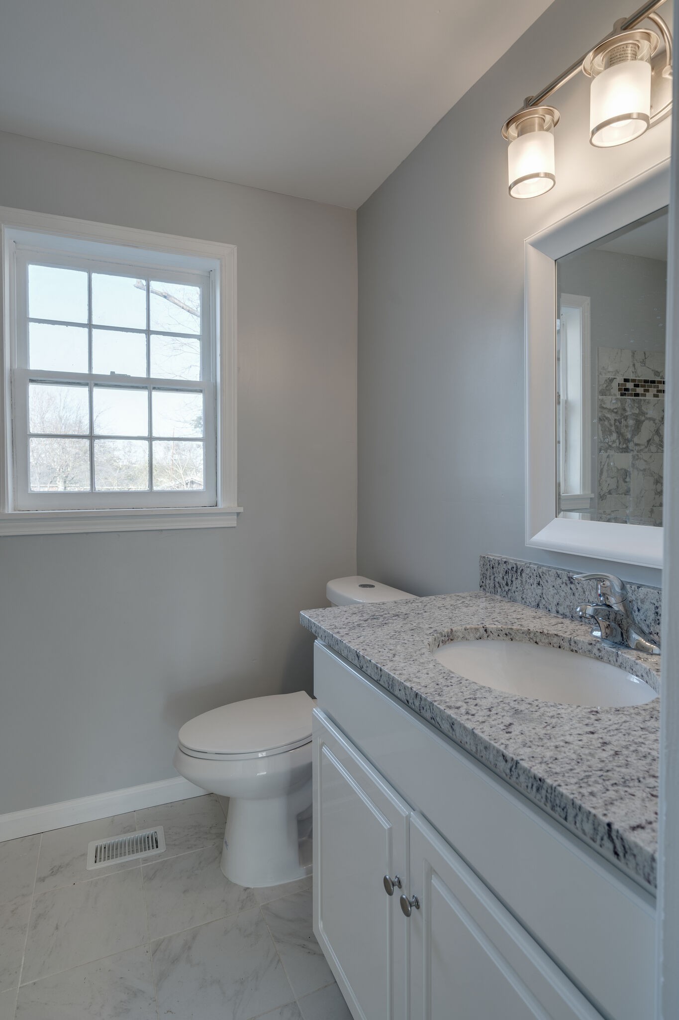 706 Pace Street Gallatin, TN 37066 - Photo 10 of 20 a bathroom with a granite countertop toilet a sink and a mirror