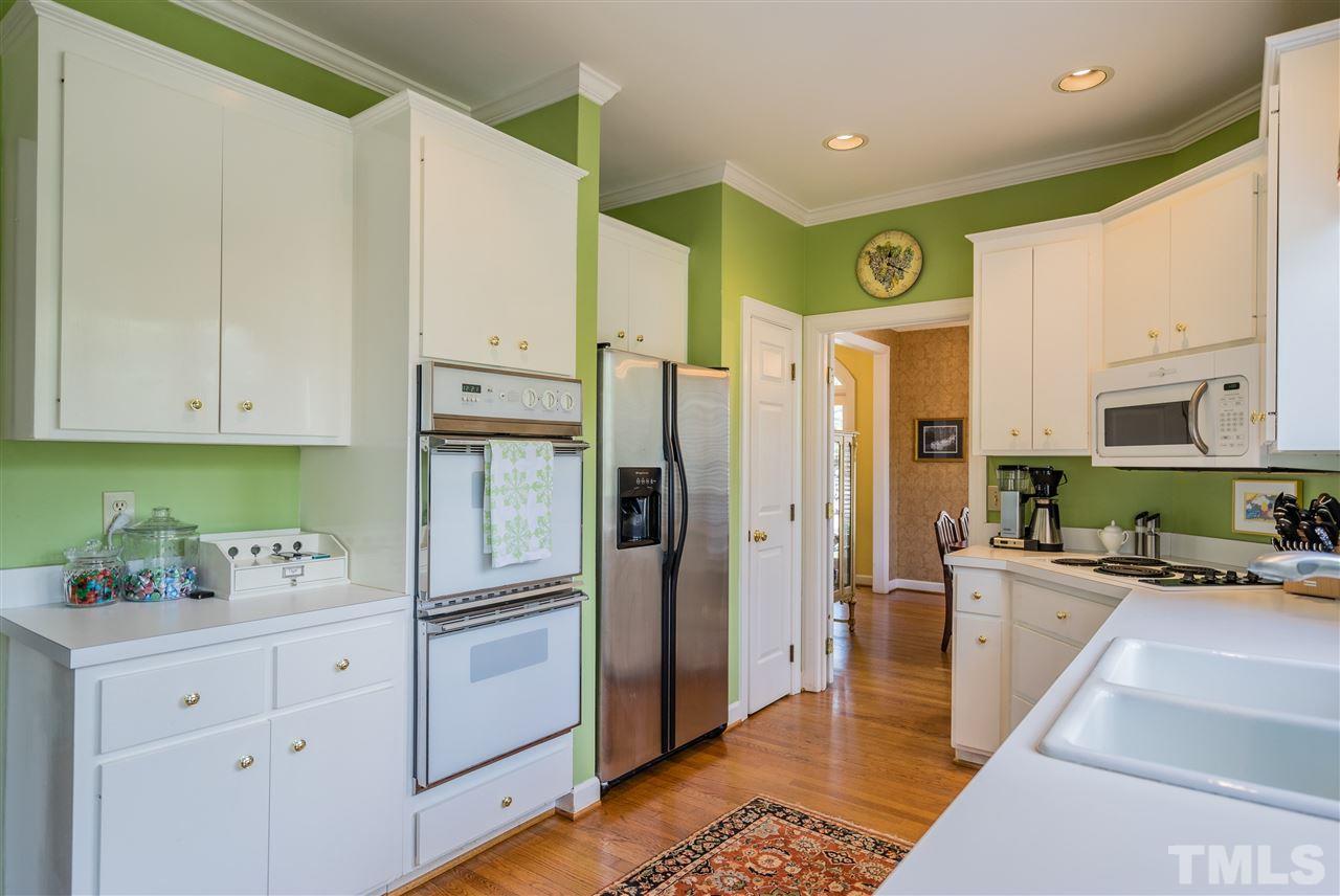 2808 Royster Street Raleigh, NC 27608 - Photo 12 of 25 a kitchen with stainless steel appliances a refrigerator sink and white cabinets
