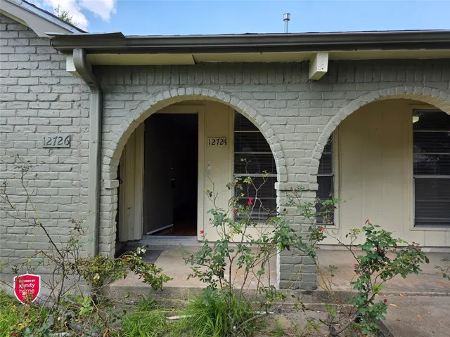 a front view of a house with plants