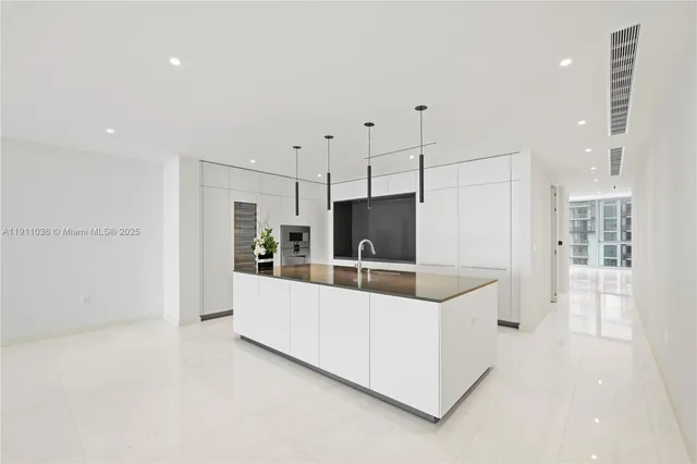a large white kitchen with cabinets and stainless steel appliances