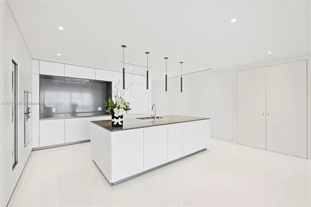 a view of white cabinets with sink and refrigerator