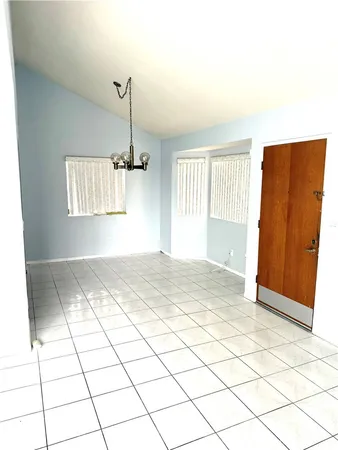 a view of empty room with kitchen and window