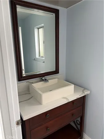 a bathroom with a sink vanity and mirror