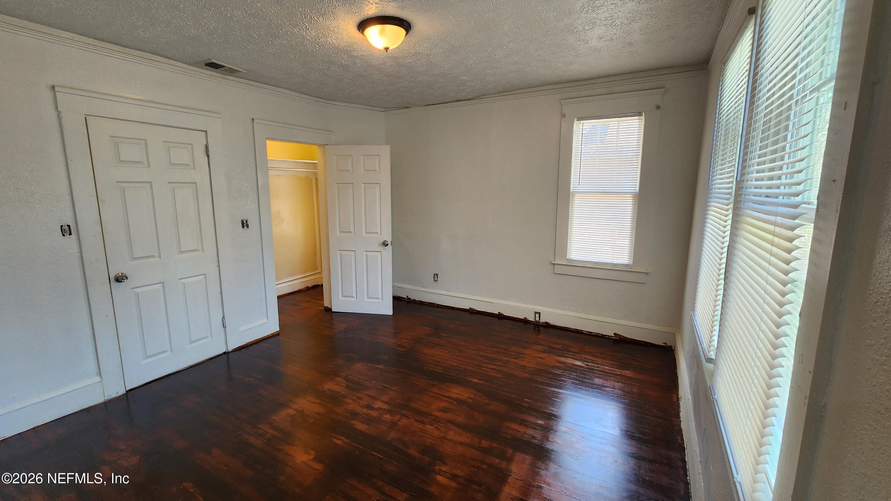 2036 Moncrief Road Jacksonville, FL 32209 - Photo 18 of 32 an empty room with wooden floor and windows