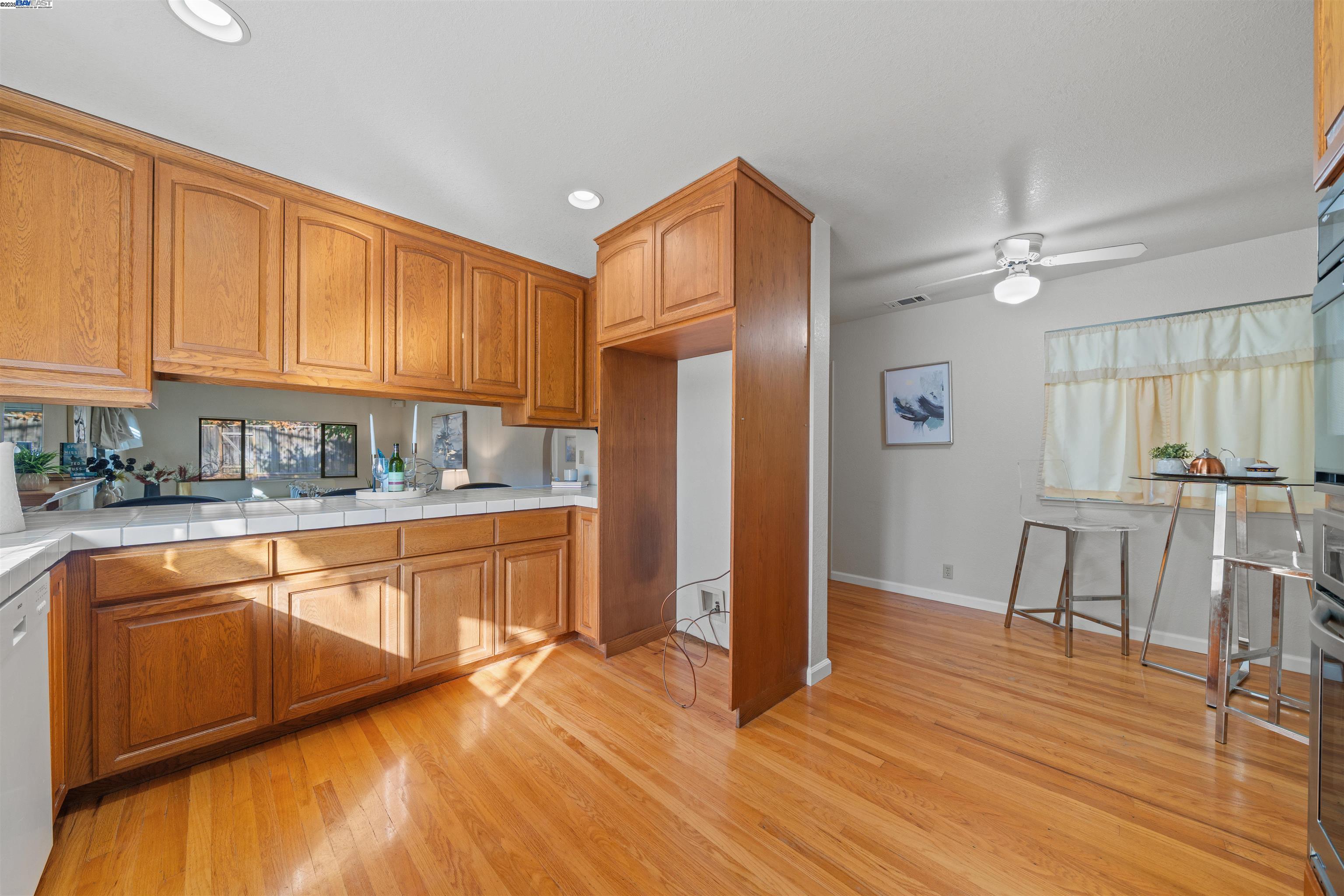 3393 Sutton Loop Fremont, CA 94536 - Photo 11 of 47 a kitchen with stainless steel appliances granite countertop a refrigerator a stove a sink dishwasher and white cabinets with wooden floor
