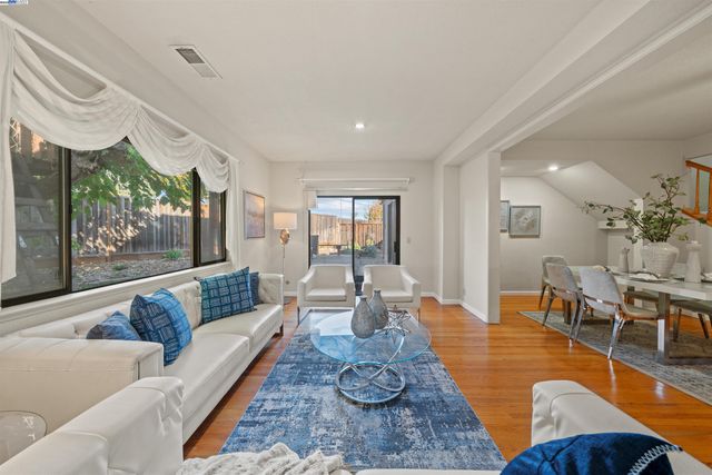 a living room with furniture wooden floor and a large window