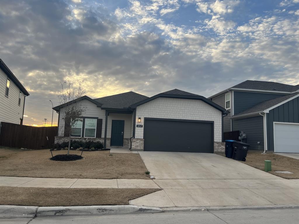 6841 Fools Gold Drive Fort Worth, TX 76179 - Photo 1 of 1 View of front of property featuring stone siding, driveway, and an attached garage
