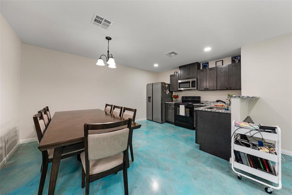3109 North 27th Street Waco, TX 76708 - Photo 7 of 17 a kitchen with stainless steel appliances granite countertop a stove top oven a refrigerator a dining table and chairs with wooden floor