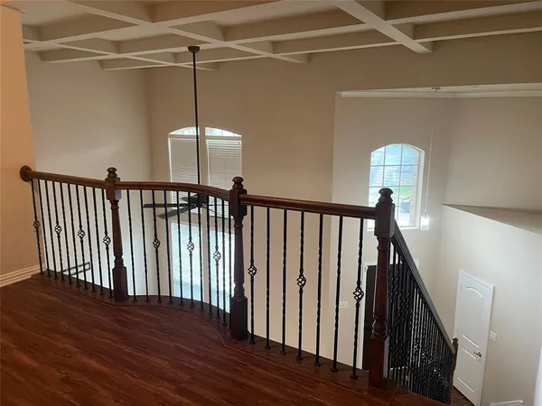 a view of a hallway with wooden floor and stairs