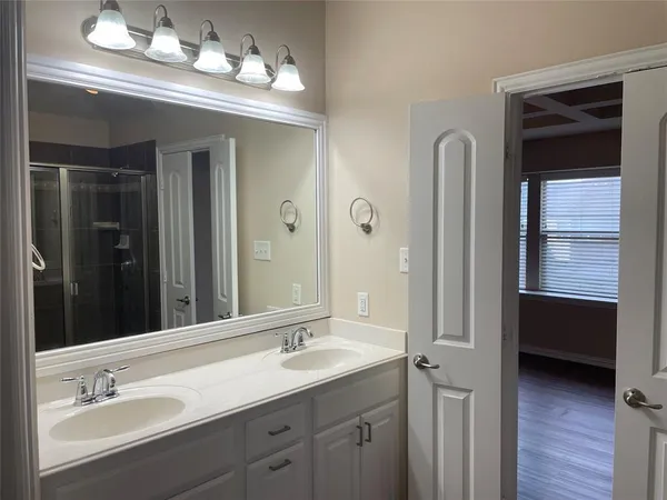 a en suite bathroom with a double vanity sink a vanity and a mirror