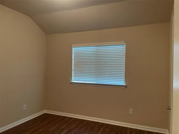 a view of a small space with wooden floor and a window