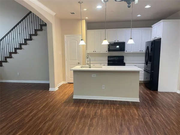 a kitchen with stainless steel appliances granite countertop a sink a stove a refrigerator and a microwave