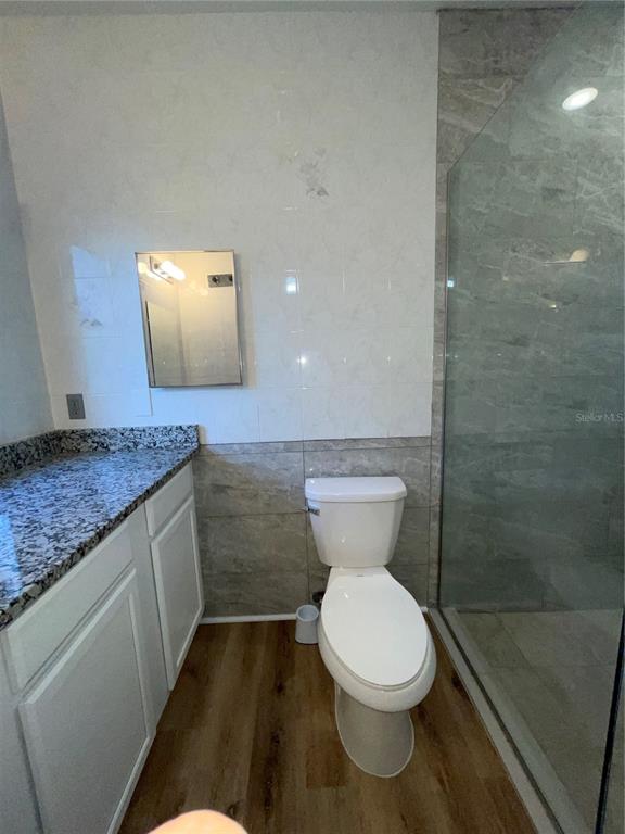 755 South Narcoossee Road St. Cloud, FL 34771 - Photo 11 of 44 a bathroom with a granite countertop toilet a sink and a shower