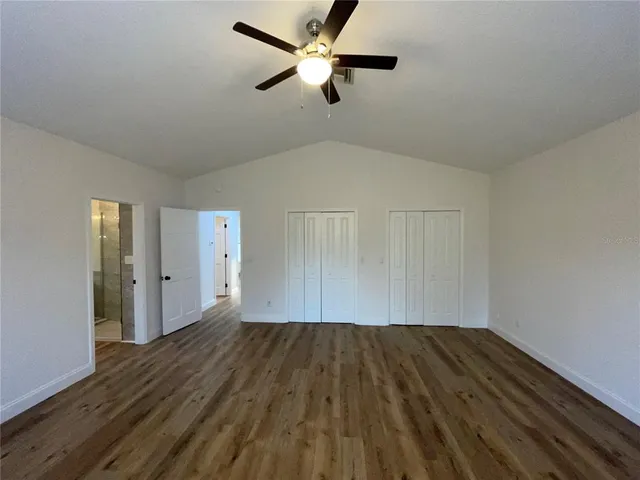 a view of room with hardwood floor and a ceiling fan