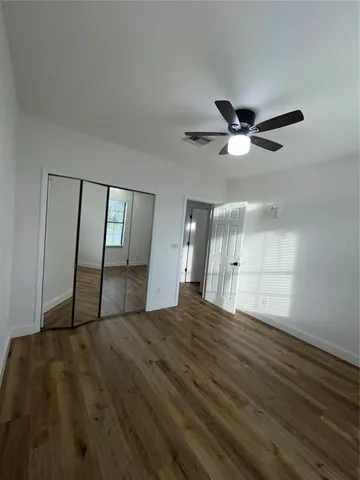 a view of empty room with wooden floor