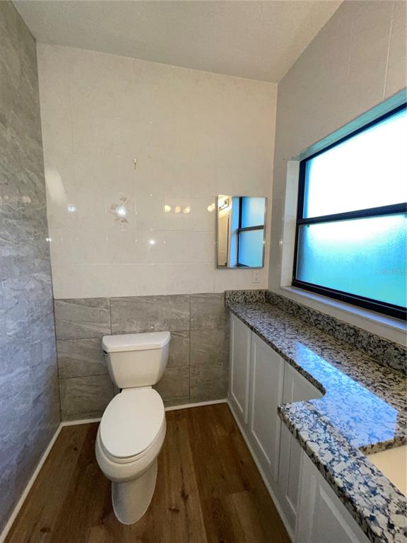 755 South Narcoossee Road St. Cloud, FL 34771 - Photo 26 of 44 a bathroom with a granite countertop toilet and a sink