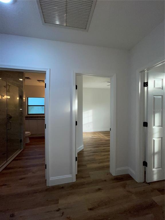 755 South Narcoossee Road St. Cloud, FL 34771 - Photo 29 of 44 a view of a hallway with wooden floor and a bathroom