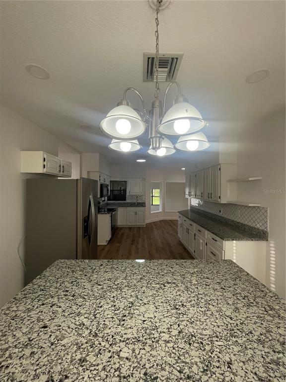 755 South Narcoossee Road St. Cloud, FL 34771 - Photo 39 of 44 a kitchen with kitchen island granite countertop a sink cabinets and stainless steel appliances