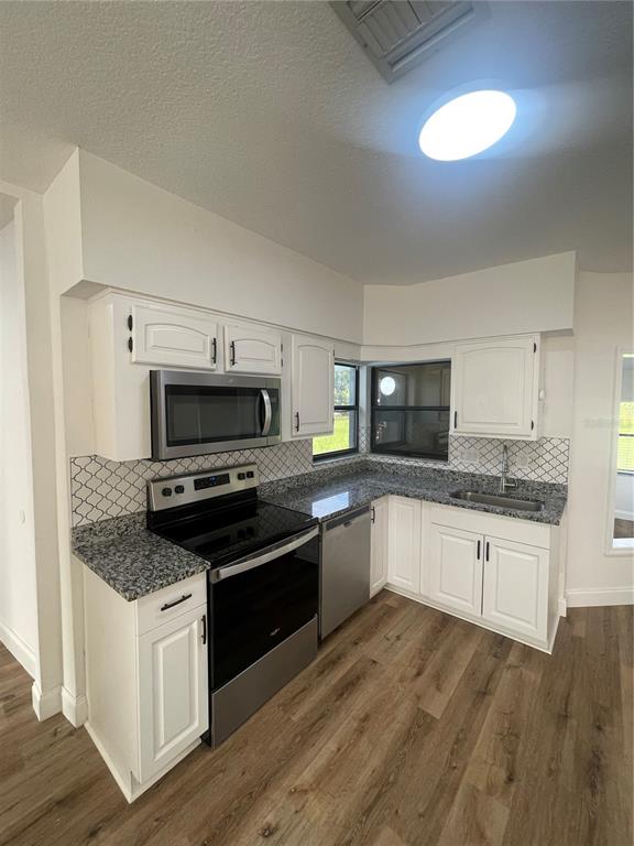 755 South Narcoossee Road St. Cloud, FL 34771 - Photo 40 of 44 a kitchen with granite countertop a stove top oven sink and cabinets