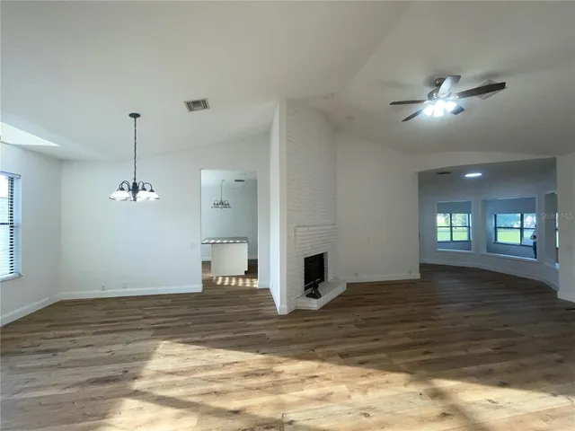 a view of a livingroom with a ceiling fan window and hardwood floor