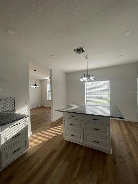 755 South Narcoossee Road St. Cloud, FL 34771 - Photo 10 of 44 a kitchen with a wooden floor and cabinets