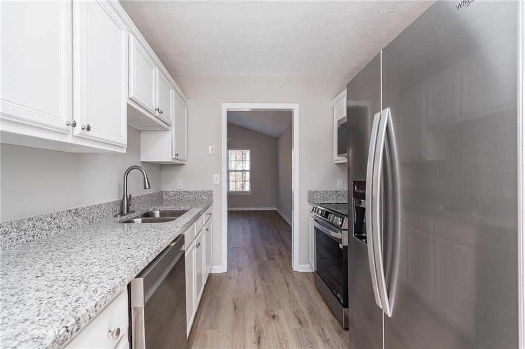 5014 Red Oak Lane Gainesville, GA 30506 - Photo 16 of 43 a kitchen with stainless steel appliances granite countertop a sink stove and refrigerator