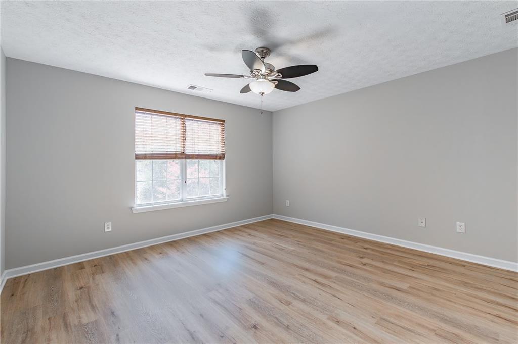 5014 Red Oak Lane Gainesville, GA 30506 - Photo 22 of 43 an empty room with wooden floor ceiling fan and windows